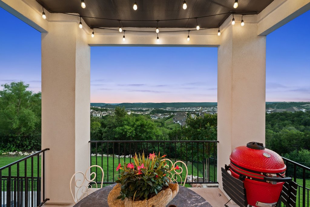 1221 Siena Sunset Road Leander, TX 78641 - Photo 4 of 39 Outdoor covered patio featuring string lighting, stucco columns, and a black metal railing