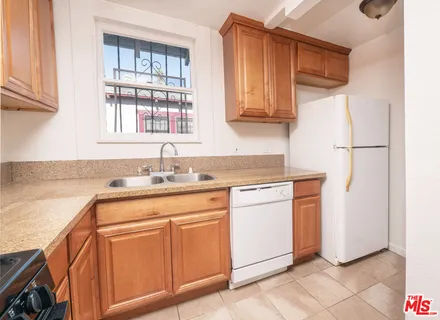 a kitchen with stainless steel appliances granite countertop a sink and a refrigerator