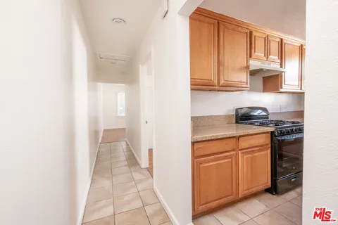 a hallway with cabinets and a stove top oven