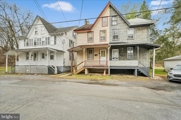 a view of a white house with large windows and a small yard