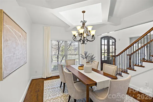 a view of a dining room with furniture a chandelier and wooden floor
