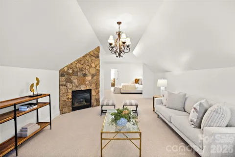 a living room with furniture a fireplace and a chandelier