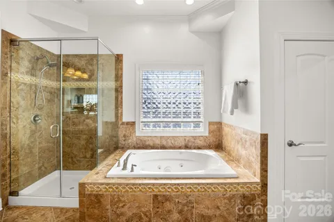 a bathroom with a tub shower and window