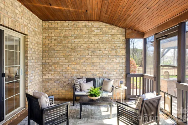 a view of a patio with couches chairs and wooden floor