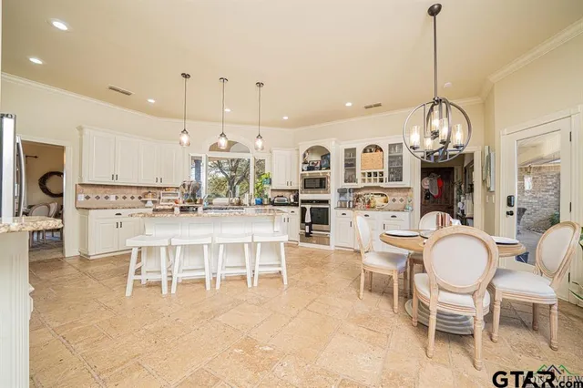 a living room with furniture a dining table and a chandelier