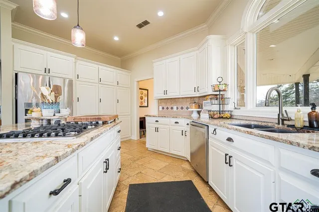 a kitchen with granite countertop a sink stove and cabinets