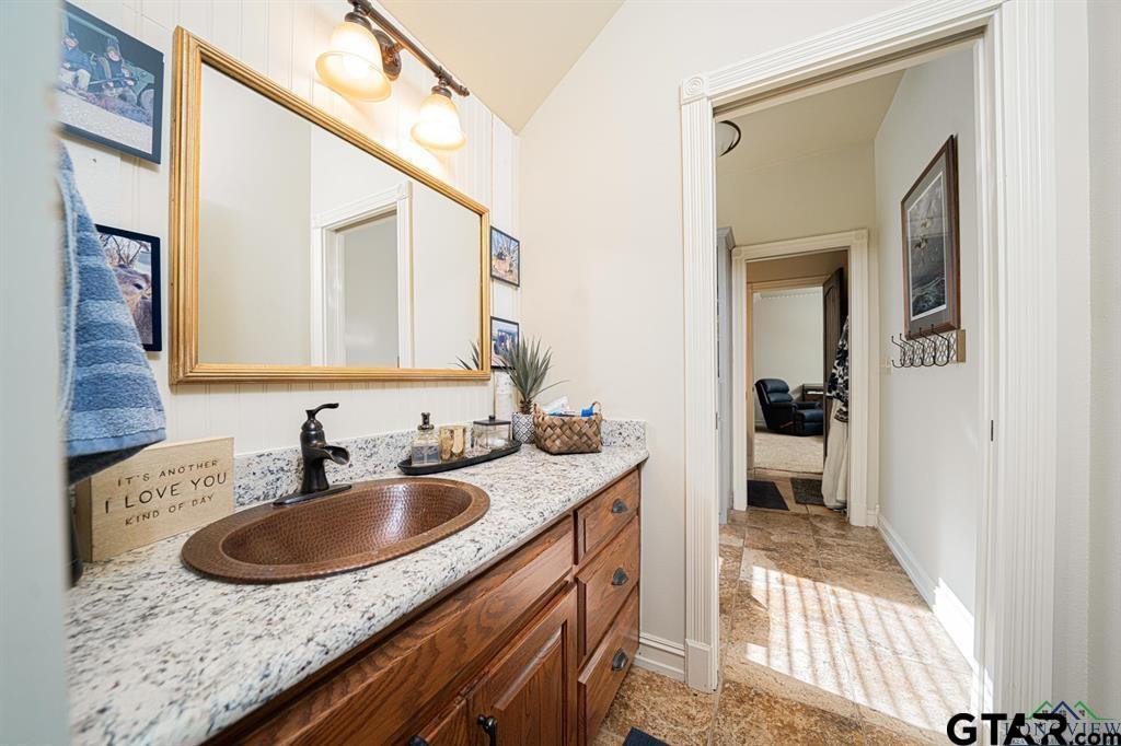 19980 FM 449 Longview, TX 75605 - Photo 22 of 48 a en suite bathroom with a granite countertop sink and a mirror