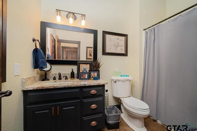 a en suite bathroom with a granite countertop sink and a mirror