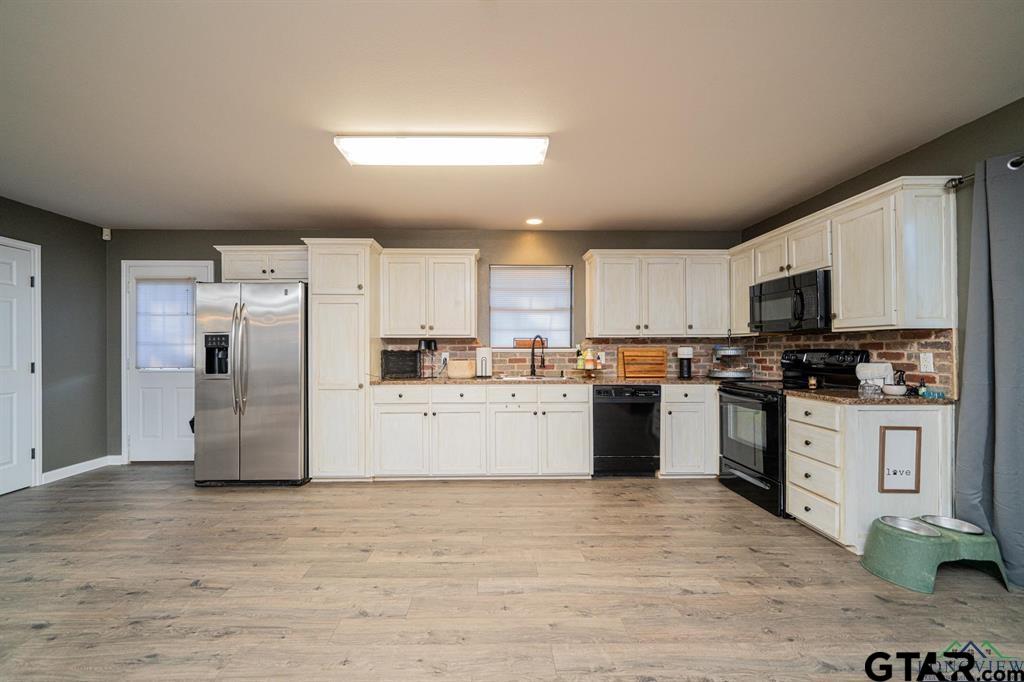 19980 FM 449 Longview, TX 75605 - Photo 33 of 48 a kitchen with granite countertop white cabinets and stainless steel appliances