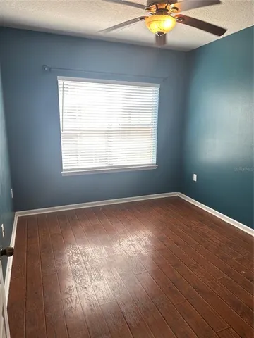 an empty room with wooden floor and a sink