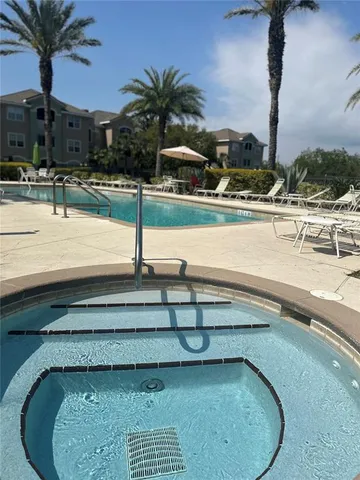 a view of a swimming pool with a chair and palm trees