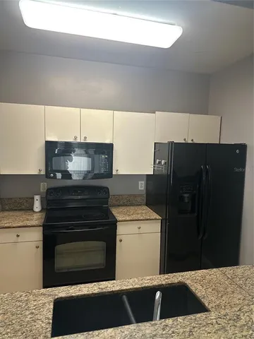 a kitchen with a stove top oven cabinets and a refrigerator