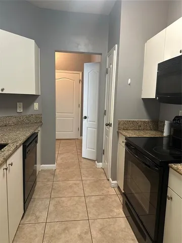 a kitchen with granite countertop a stove and a refrigerator