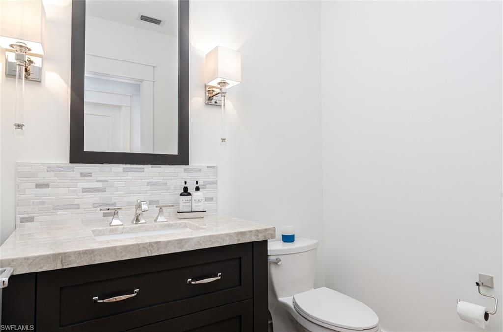 930 9th Street South, Unit 930 Naples, FL 34102 - Photo 15 of 17 a bathroom with a toilet sink and mirror