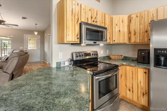 a kitchen with stainless steel appliances granite countertop a stove a sink and a microwave