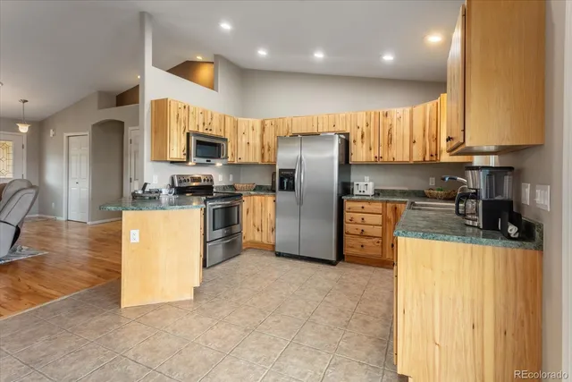 a kitchen with stainless steel appliances granite countertop a refrigerator a stove a sink and a microwave