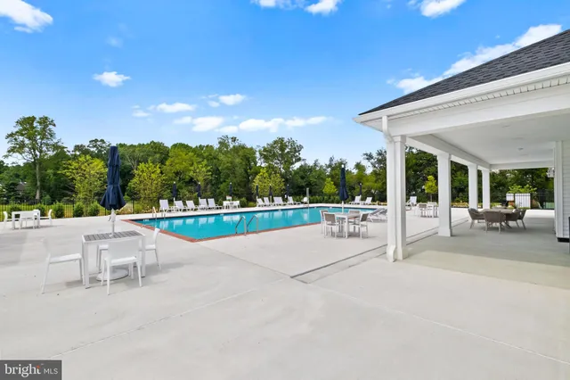 a view of a patio with table and chairs potted plants with floor to ceiling window