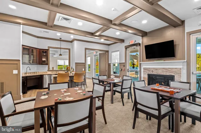 a view of a dining room with furniture a fireplace and wooden floor