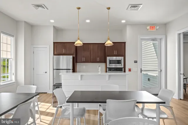 a kitchen with kitchen island a counter top space a sink stainless steel appliances and cabinets