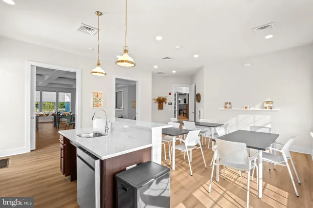 a view of a dining room and livingroom with furniture wooden floor a rug a chandelier and a view