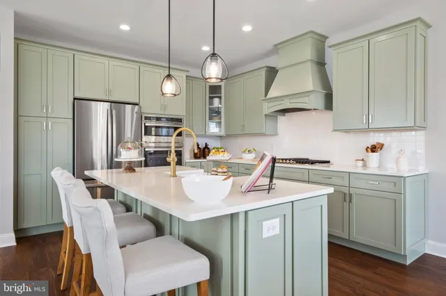 a kitchen with a sink a refrigerator and chairs