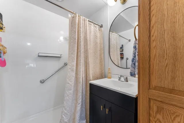 a bathroom with a sink mirror and a shower