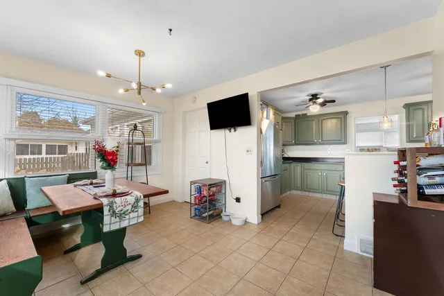a living room with furniture a flat screen tv and kitchen view
