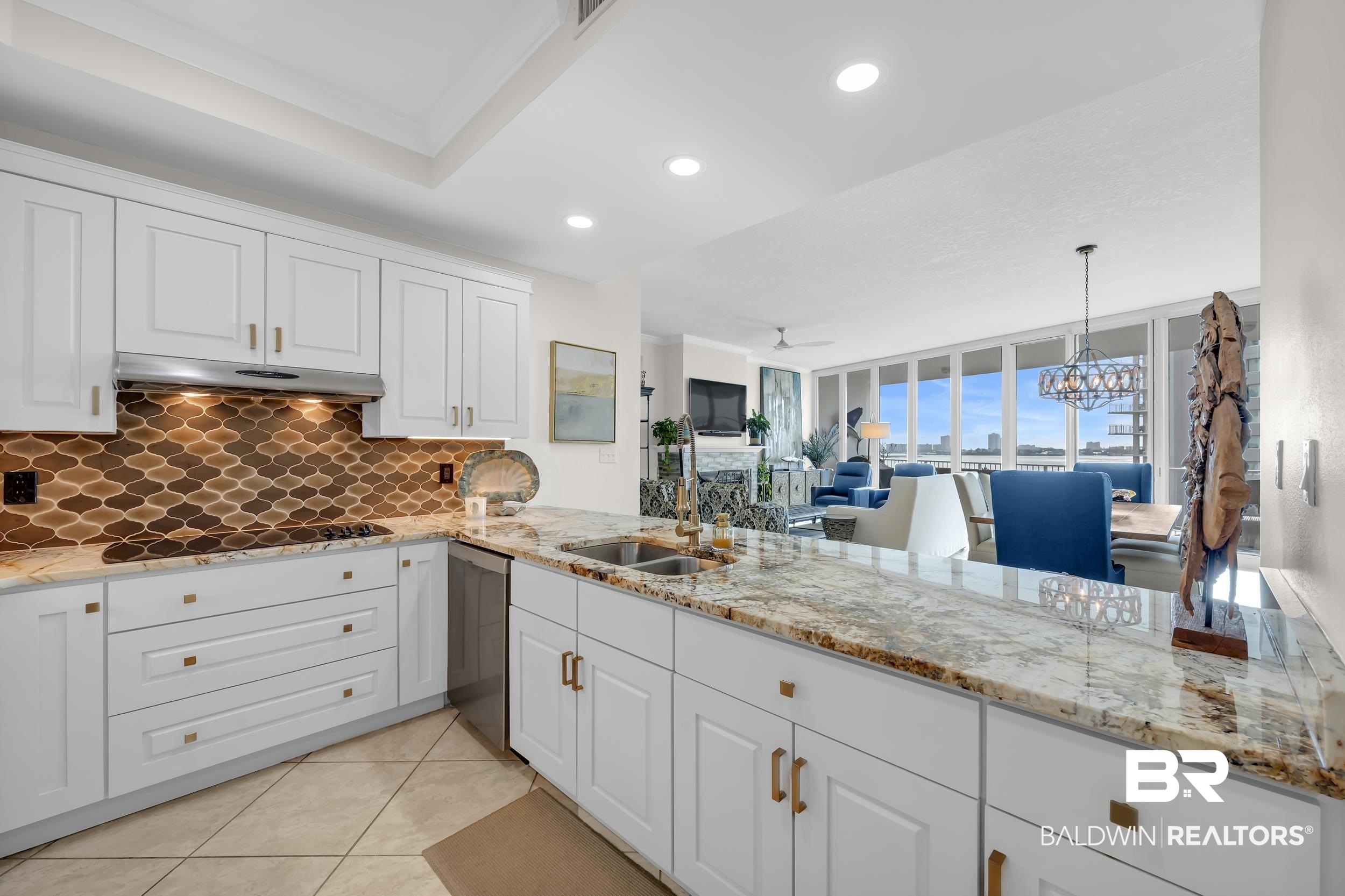 28250 Canal Road, Unit 307 Orange Beach, AL 36561 - Photo 18 of 56 Kitchen featuring light stone counters, a ceiling fan, white cabinetry, and light tile patterned flooring