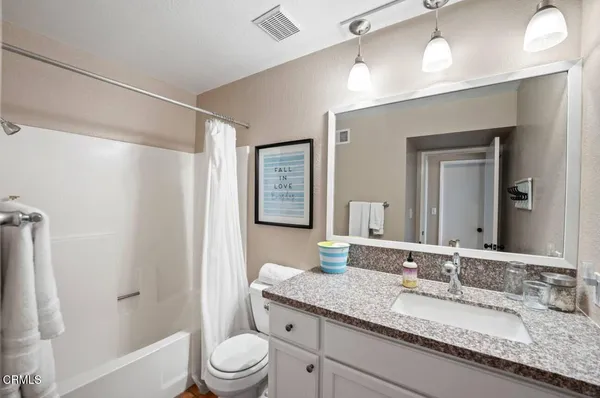 a bathroom with a granite countertop sink toilet a large mirror a vanity and shower