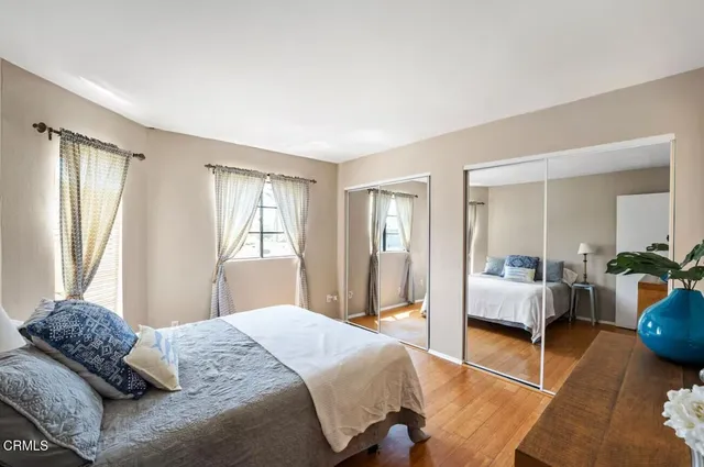 a bedroom with a large bed and windows