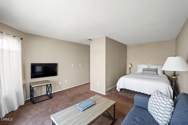 a bedroom with a bed and a flat screen tv