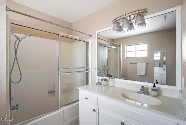 a bathroom with a double vanity sink mirror and shower