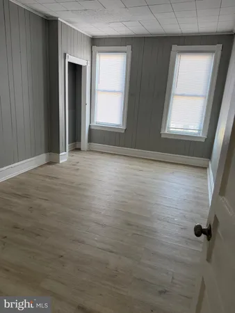 a view of an empty room with closet and window