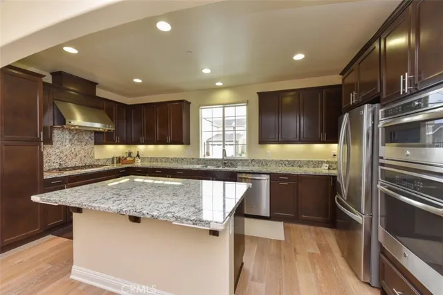 a kitchen with stainless steel appliances granite countertop a sink stove and refrigerator
