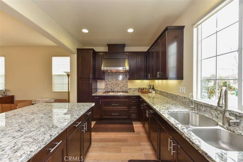 122 Bumblebee Irvine, CA 92618 - Photo 7 of 21 a kitchen with granite countertop kitchen island a sink stove and cabinets