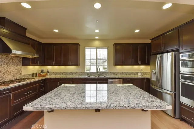a large kitchen with a large counter top stainless steel appliances and a counter space