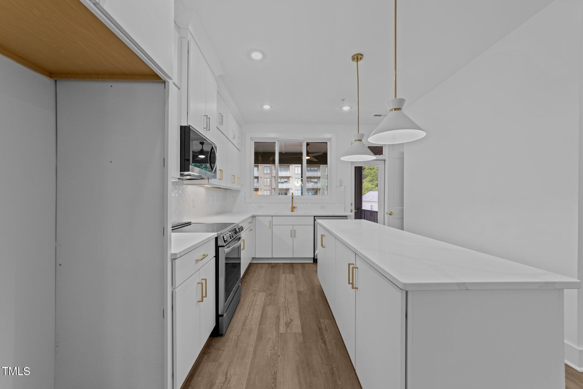 710 West North Street, Unit 102 Raleigh, NC 27603 - Photo 19 of 37 a kitchen with cabinets a sink and appliances