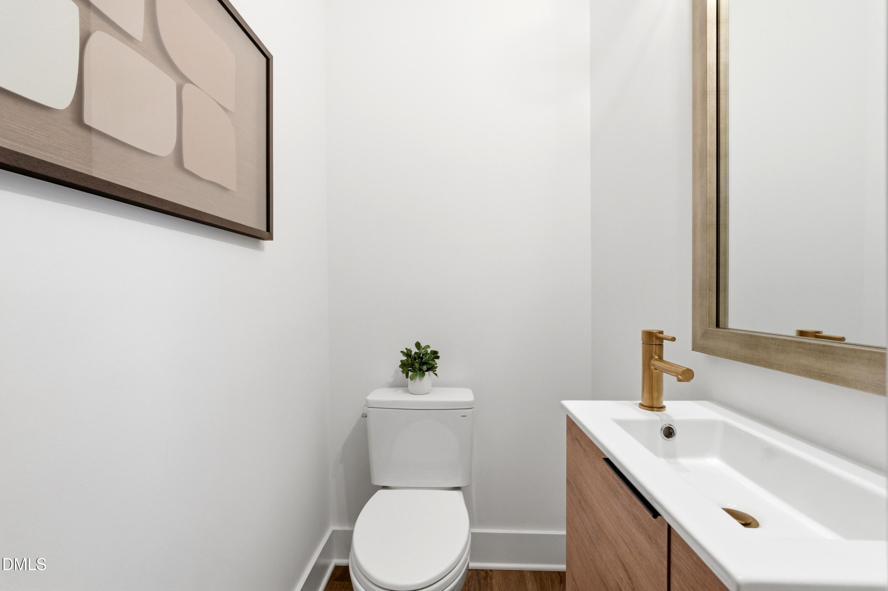 710 West North Street, Unit 102 Raleigh, NC 27603 - Photo 23 of 44 a bathroom with a sink a toilet and mirror