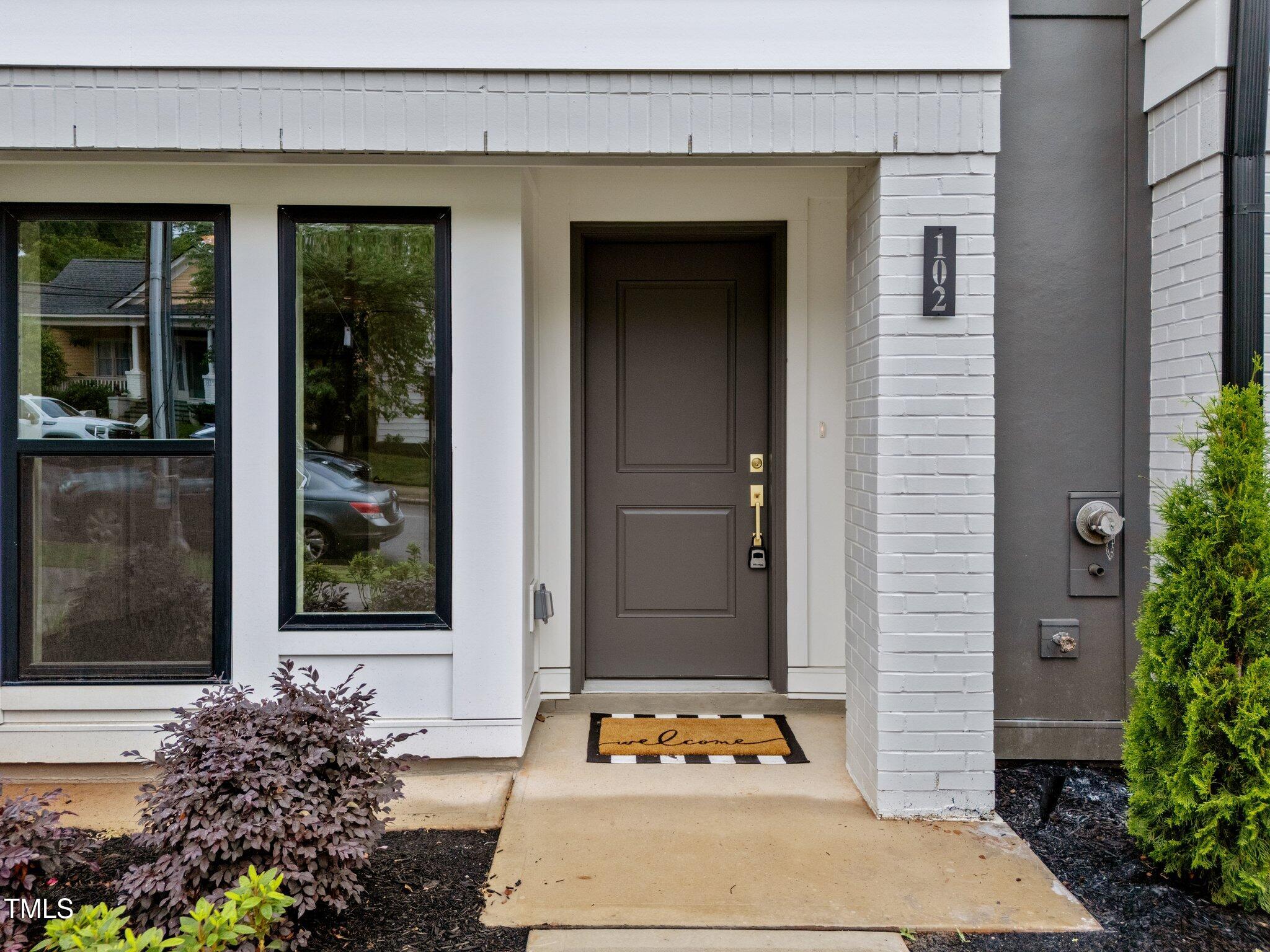 710 West North Street, Unit 102 Raleigh, NC 27603 - Photo 3 of 44 a front view of a house with a potted plant