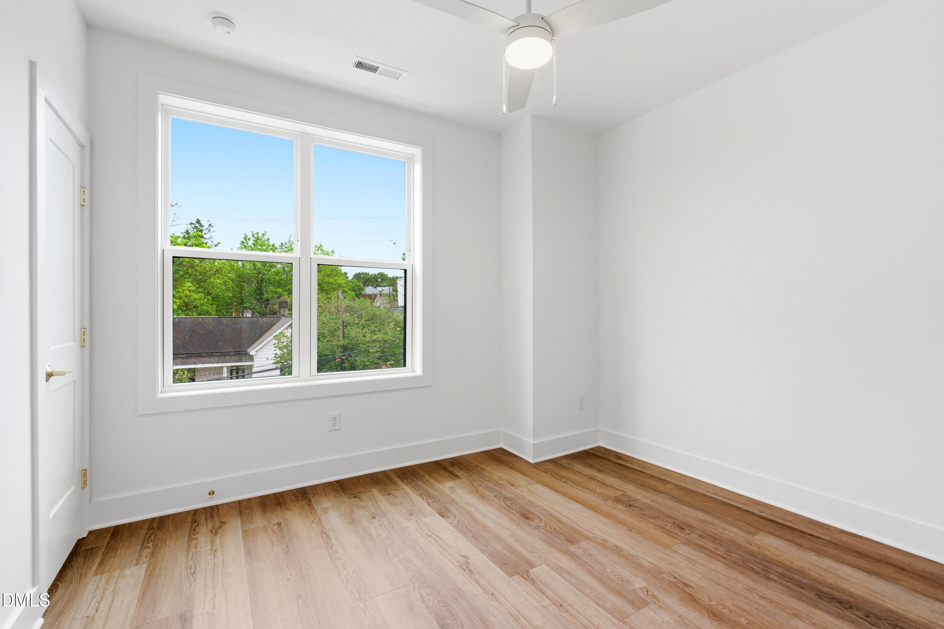 710 West North Street, Unit 102 Raleigh, NC 27603 - Photo 31 of 44 an empty room with wooden floor and windows