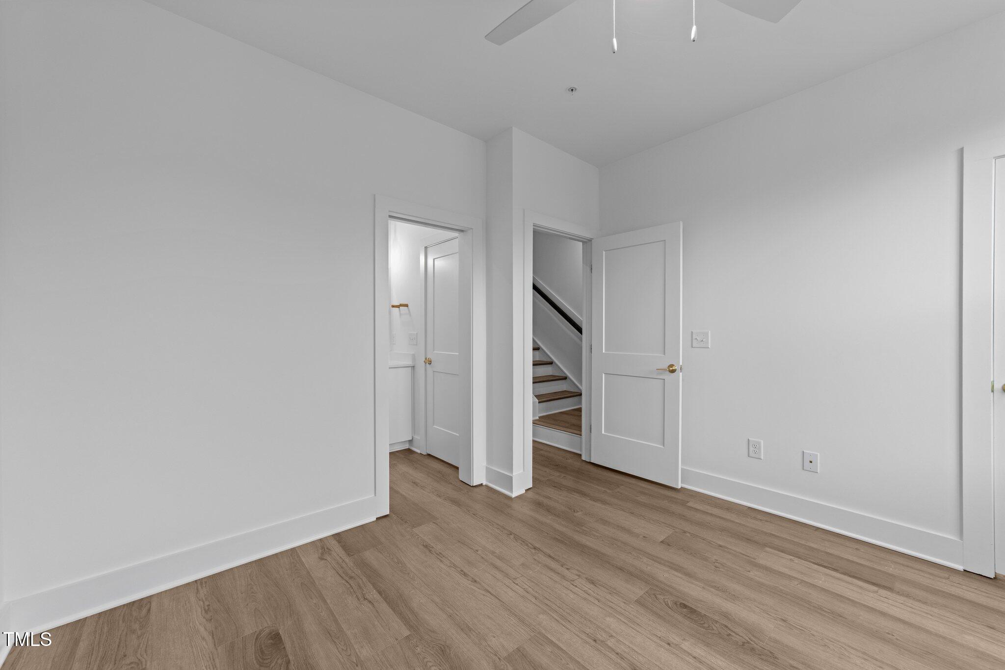 710 West North Street, Unit 102 Raleigh, NC 27603 - Photo 33 of 44 an empty room with wooden floor and empty racks