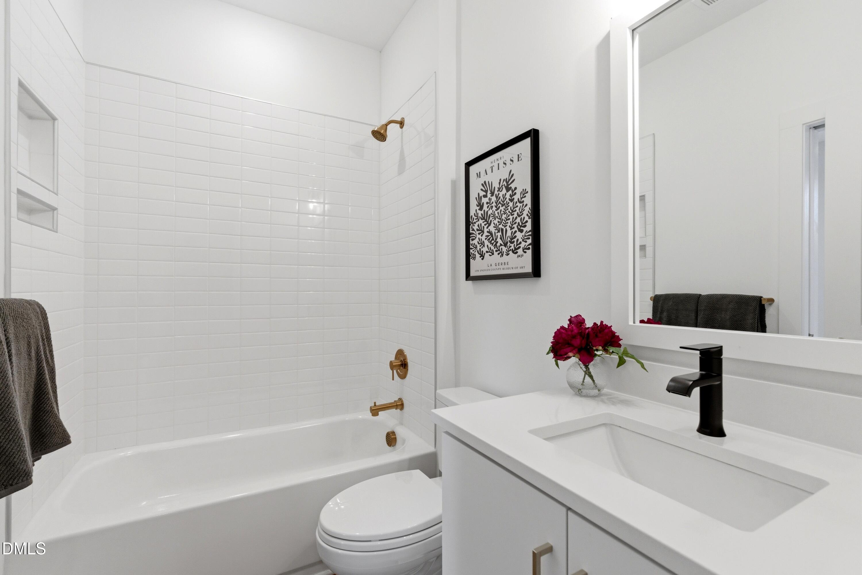 710 West North Street, Unit 102 Raleigh, NC 27603 - Photo 35 of 44 a bathroom with a granite countertop sink a toilet and a bathtub