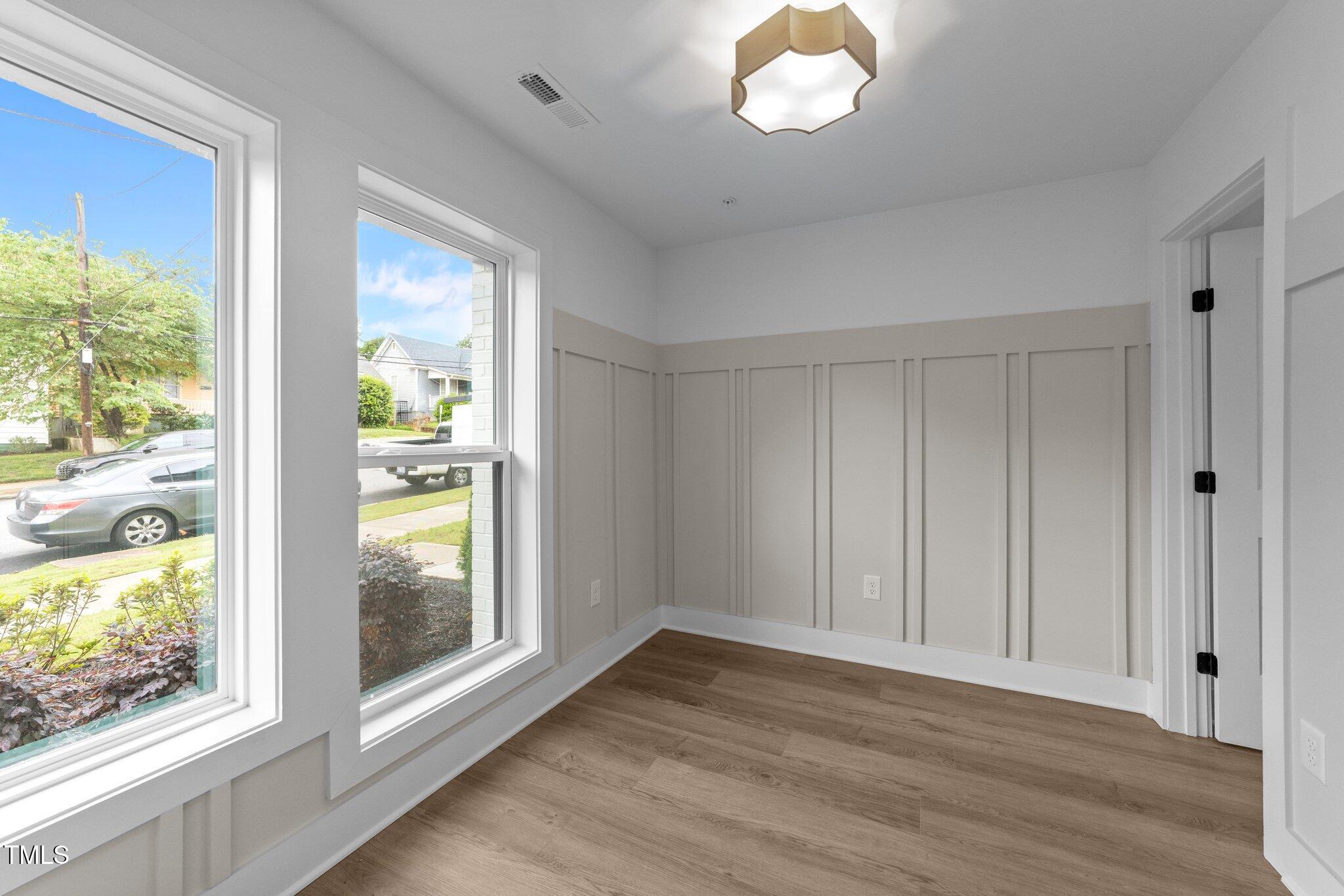710 West North Street, Unit 102 Raleigh, NC 27603 - Photo 9 of 37 a view of an empty room with a window and wooden floor