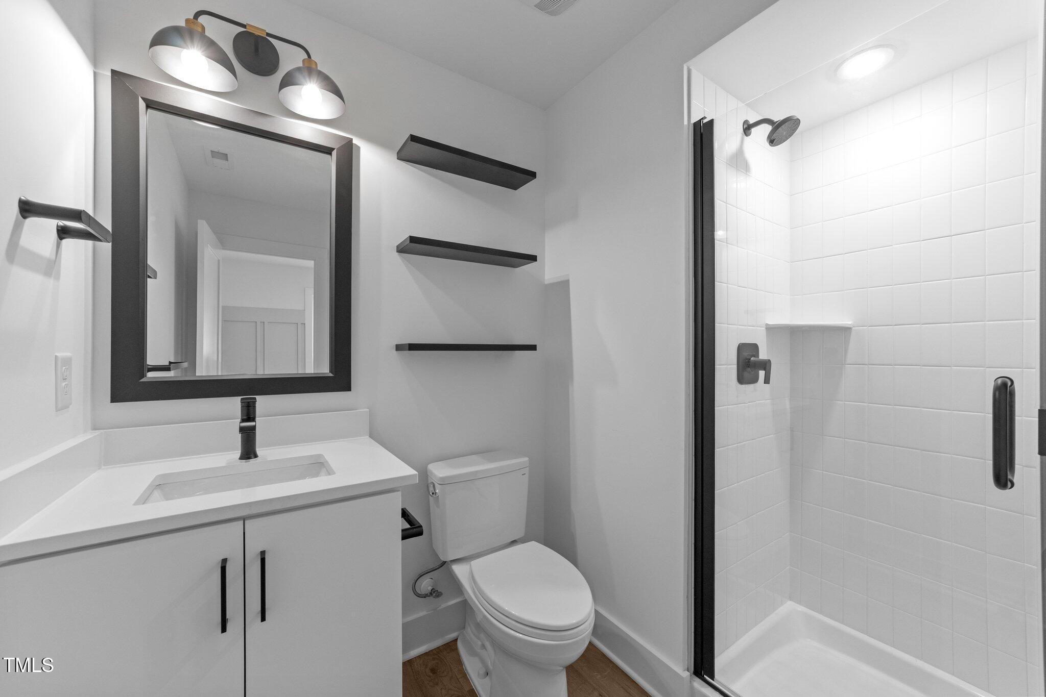 710 West North Street, Unit 102 Raleigh, NC 27603 - Photo 9 of 44 a bathroom with a toilet sink and mirror