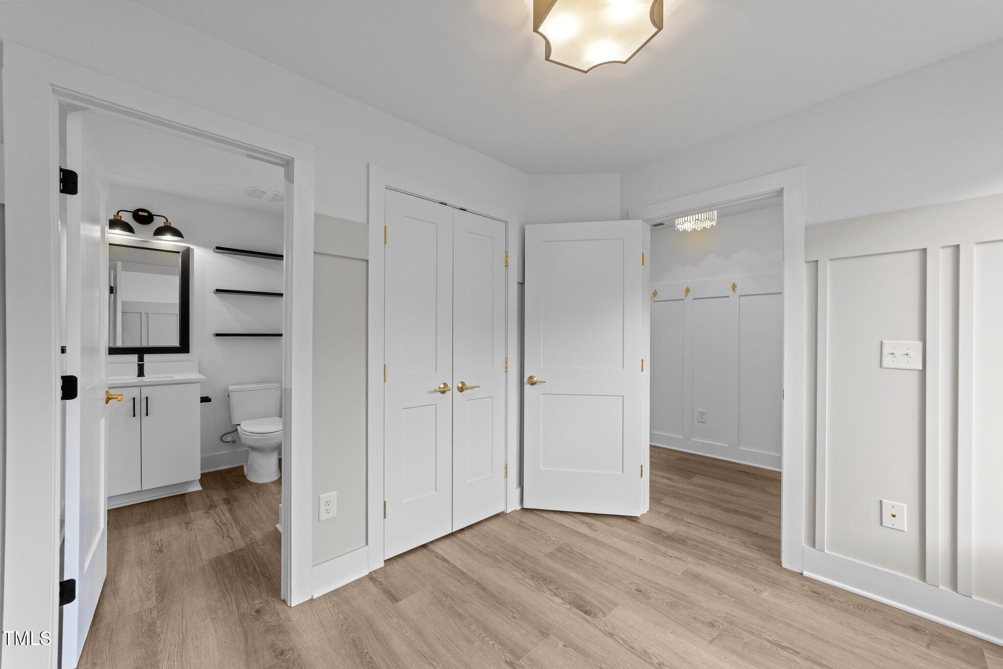 710 West North Street, Unit 102 Raleigh, NC 27603 - Photo 10 of 37 a view of a bathroom with a toilet a mirror and a hardwood