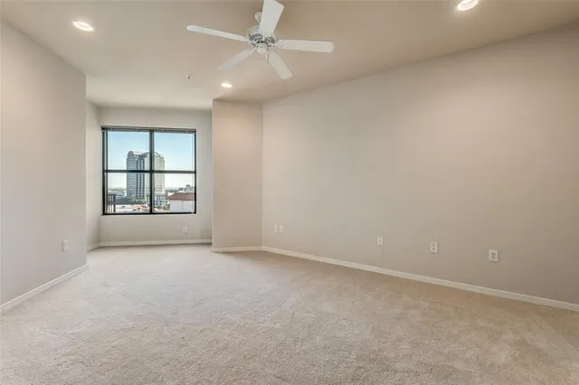 an empty room with windows and ceiling fan