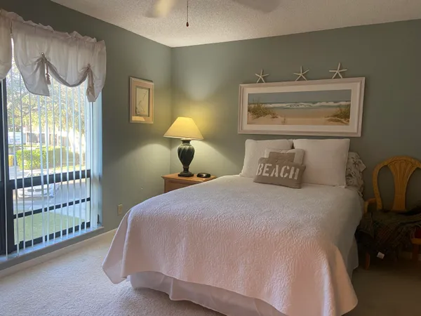 a bedroom with a bed and lamp next to a window