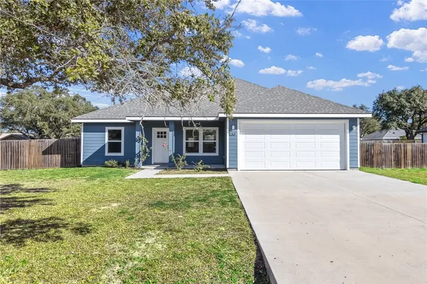 a kitchen with stainless steel appliances granite countertop a stove a refrigerator and a sink with wooden floors