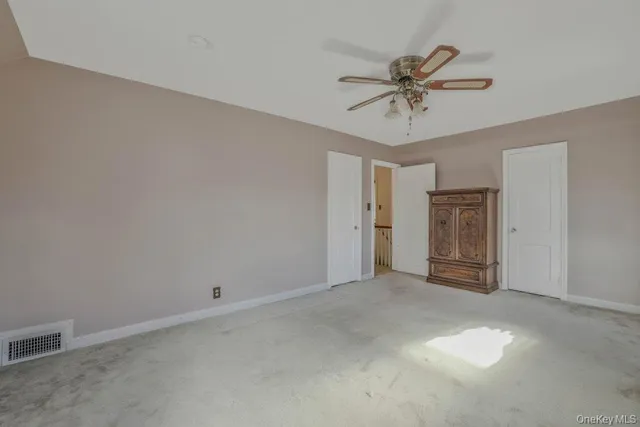 a view of hallway with a chandelier fan and a window