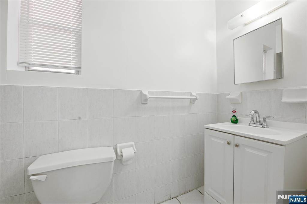 44 1/2 3rd Street, Unit 2 Newark, NJ 07107 - Photo 11 of 15 a bathroom with a toilet sink and mirror